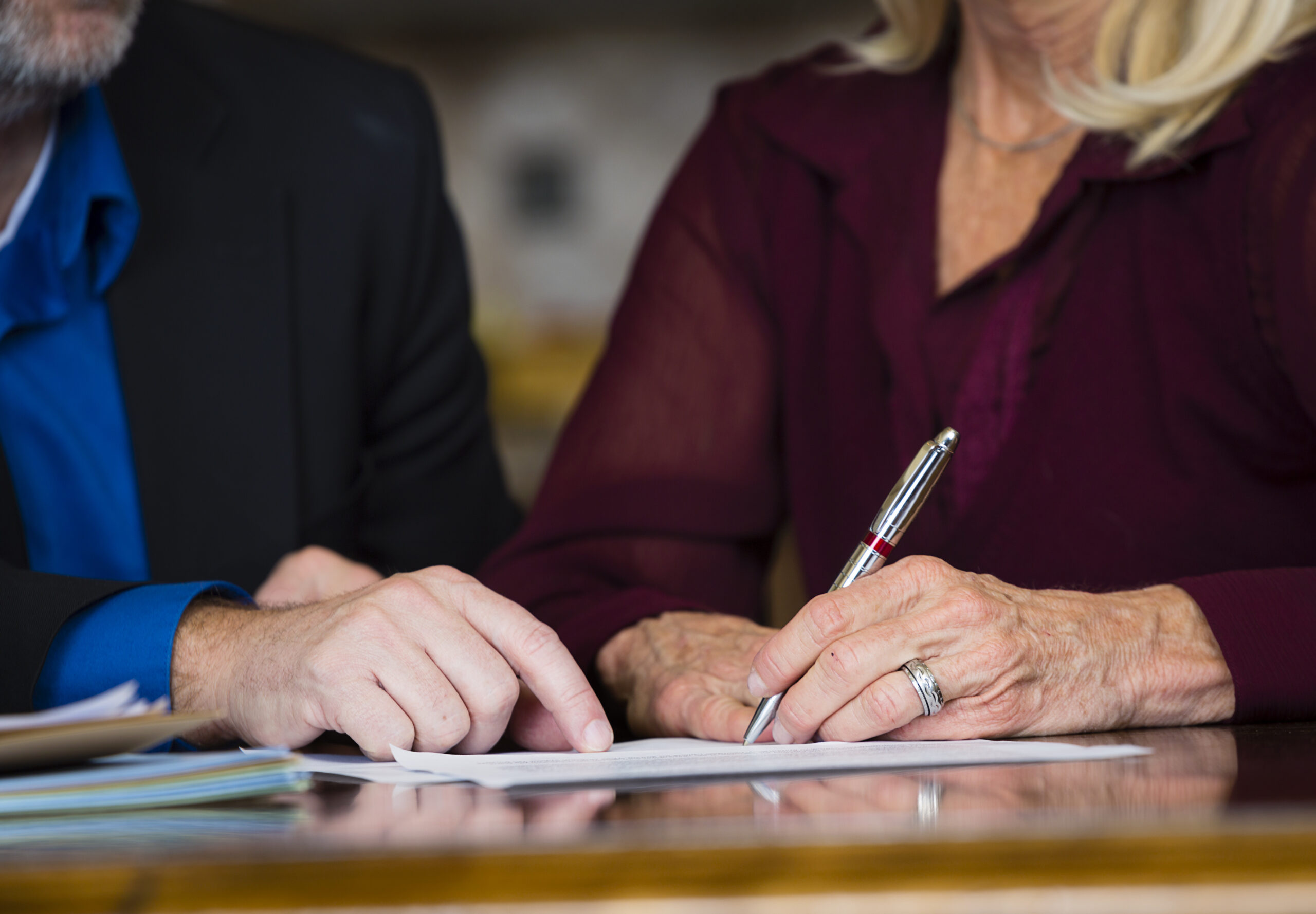 A senior citizen signing a document.